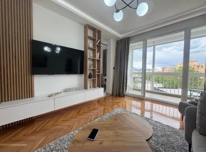 Living room with TV unit and access to the terrace.