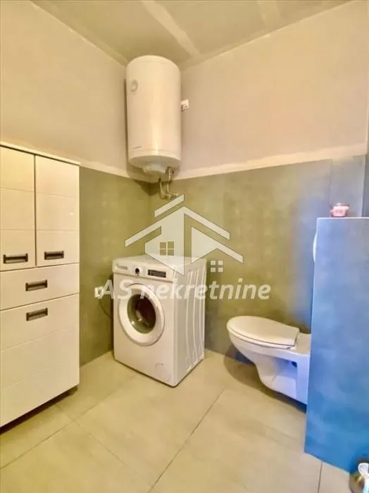 Bathroom equipped with a toilet, washing machine, and water heater.