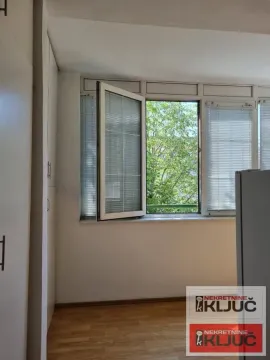 Pogled kroz otvoreni prozor na zelenilo i drveće. - image 7