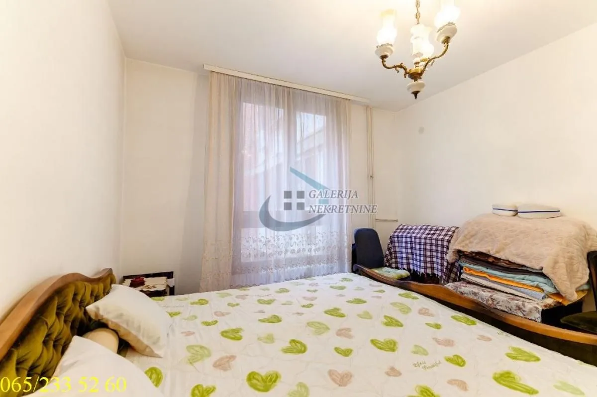 Furnished bedroom with a double bed and a window.