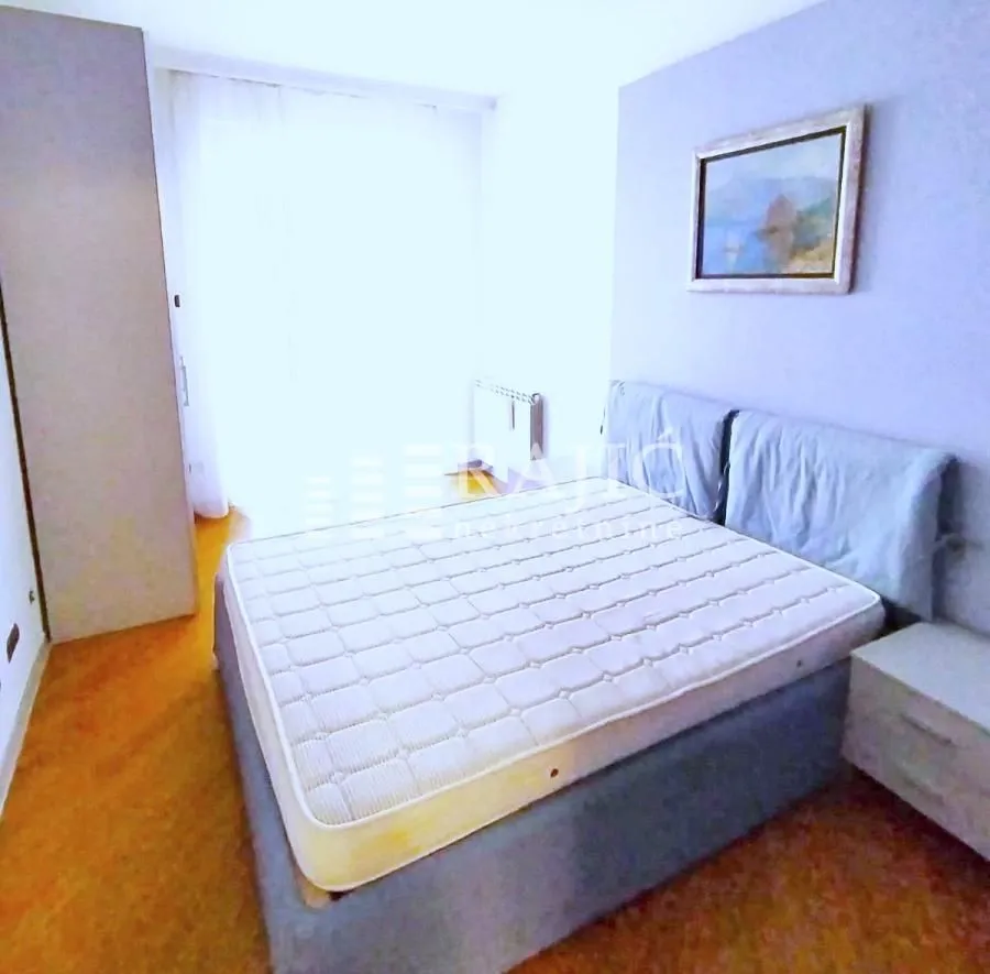 Bedroom with a double bed, wardrobe, and a painting on the wall.