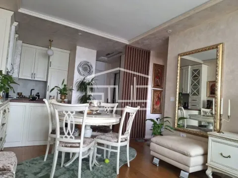 Trpezarija sa stolom i stolicama, povezana sa kuhinjom u pozadini. - image 2