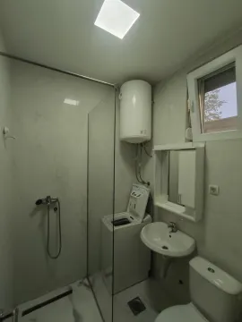 Bright bathroom with a shower cabin, washing machine, and boiler. - image 6