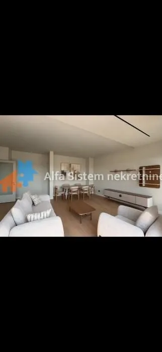 Prostrani dnevni boravak sa garniturom i trpezarijom.