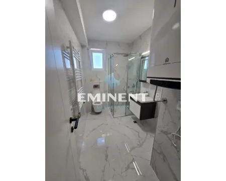 Modern bathroom with a shower cabin, washbasin, and toilet. - image 9