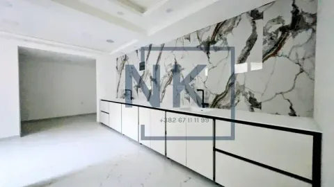 Modern kitchen with white cabinetry and a marble backsplash. - image 7
