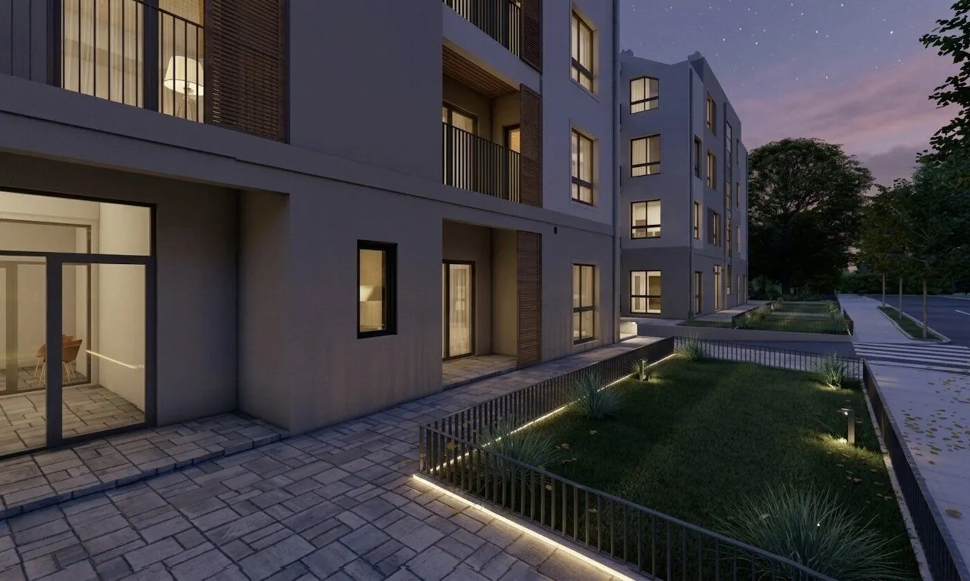 Exterior of a modern residential building in the evening with lighting.