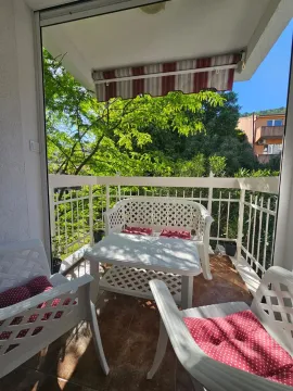 Natkriveni balkon sa garniturom za sjedenje i pogledom na zelenilo. - image 8