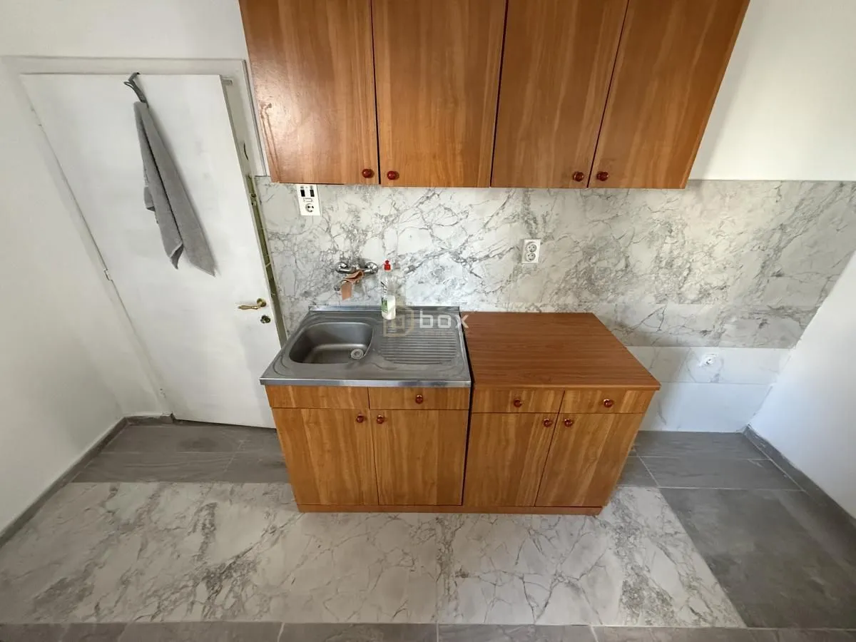 Small kitchen with a sink and wooden cabinets.