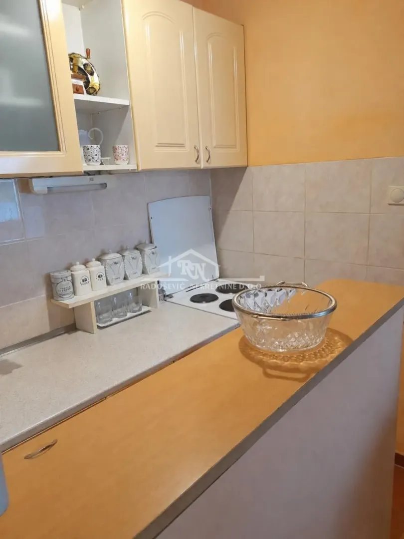 Pogled na manju kuhinju sa radnim elementima i šporetom.