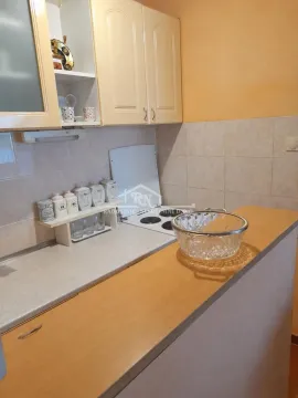 Pogled na manju kuhinju sa radnim elementima i šporetom. - image 12