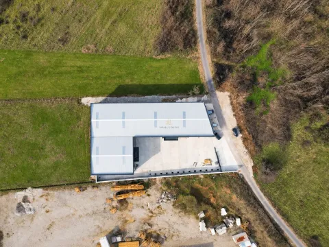Aerial view of the warehouse with surrounding land and access road. - image 5