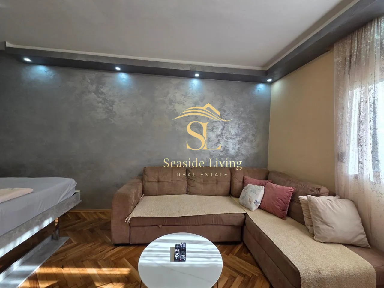 Living room with a sectional sofa, coffee table, and decorative wall.