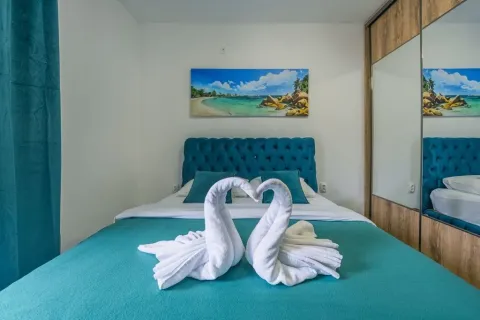 Bedroom with a double bed and decorative towels. - image 10