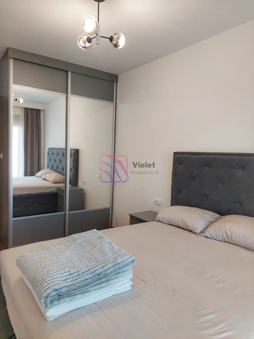 Bedroom with a double bed and a large fitted wardrobe with a mirror.