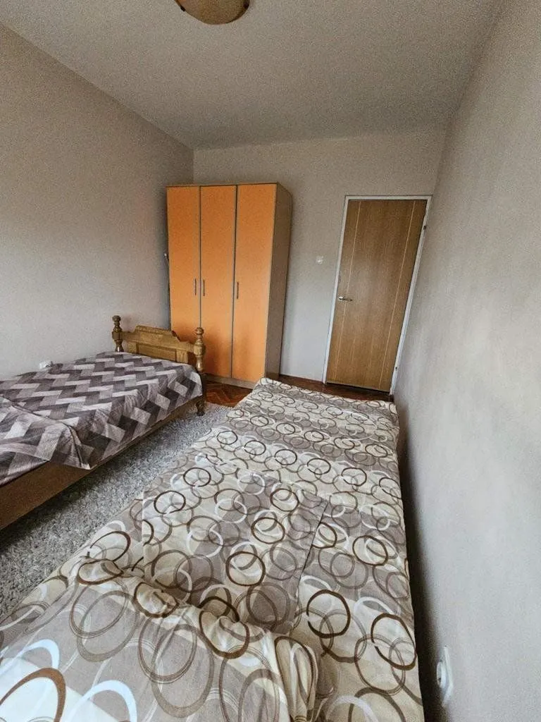 Spavaća soba sa dva kreveta i plakarom.