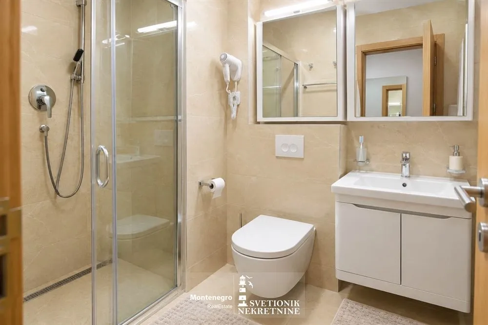 Moderno opremljeno kupatilo sa tuš kabinom, umivaonikom i wc šoljom.
