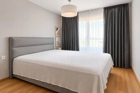 Modern bedroom with a large double bed and dark curtains. - image 7