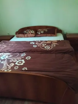 Spavaća soba sa bračnim krevetom i drvenim namještajem. - image 7