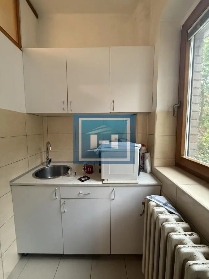 Small kitchen with white cabinets, a sink, and a countertop.