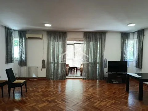 Spacious living room with wooden parquet flooring, television, and access to the terrace. - image 3