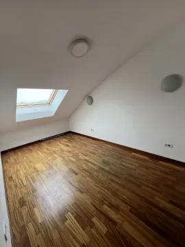 Empty attic room with a skylight and wooden flooring. - image 18