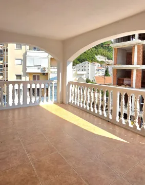 Velika prostrana terasa sa balustradama i pogledom na okolne zgrade i brdo. - image 2
