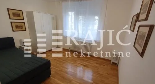 Furnished bedroom with a bed, wardrobe, and framed pictures on the wall.