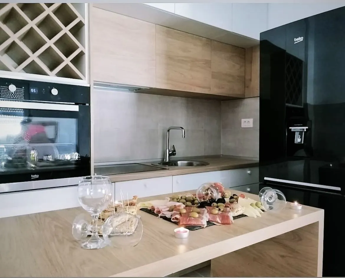 A modern kitchen with built-in appliances and a food platter on the counter.