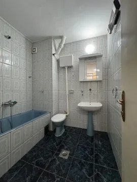 Smaller bathroom with a bathtub, sink, and toilet. - image 12