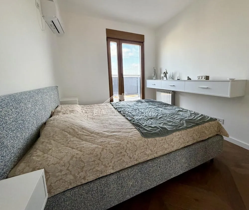 Spavaća soba sa bračnim krevetom i izlazom na terasu.