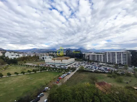 Pogled sa prozora na gradski pejzaž i planine u daljini. - image 4