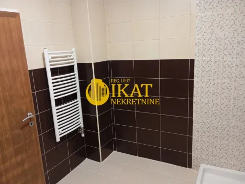 Bathroom with brown and beige tiles and a white radiator. - image 10