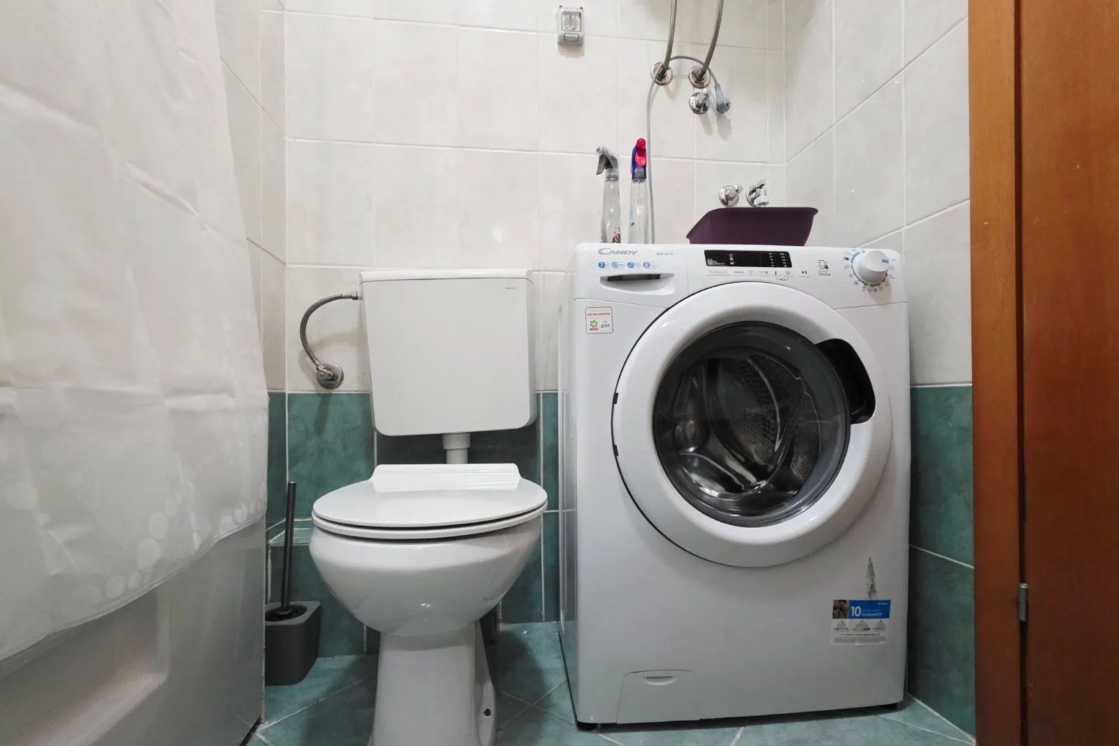 Small bathroom with a toilet and a washing machine.