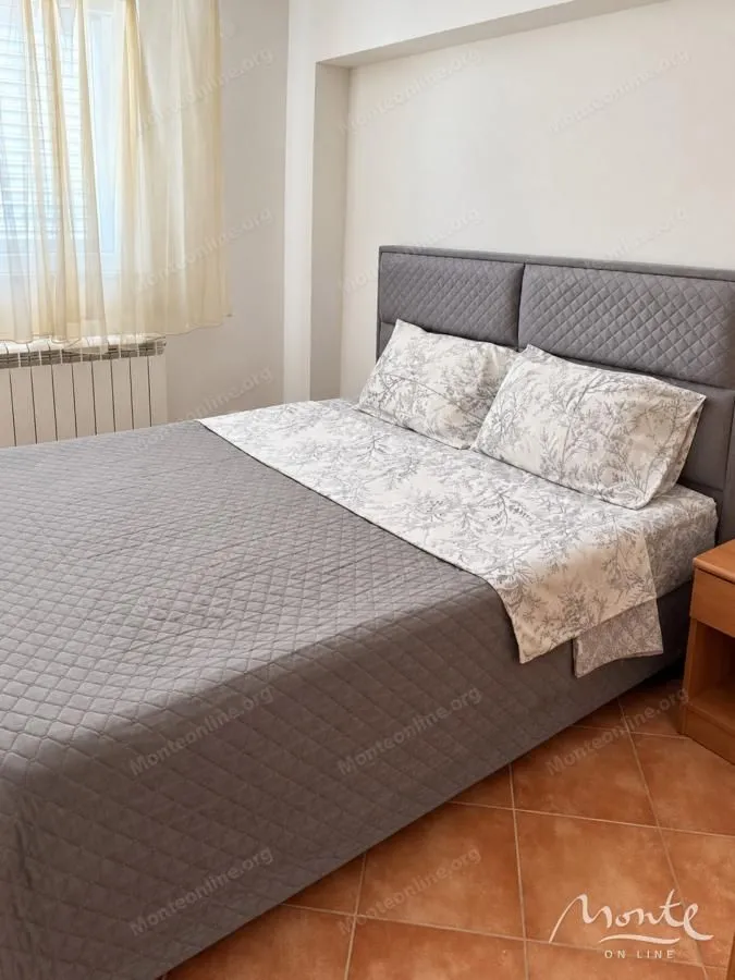 Namještena spavaća soba sa bračnim krevetom.