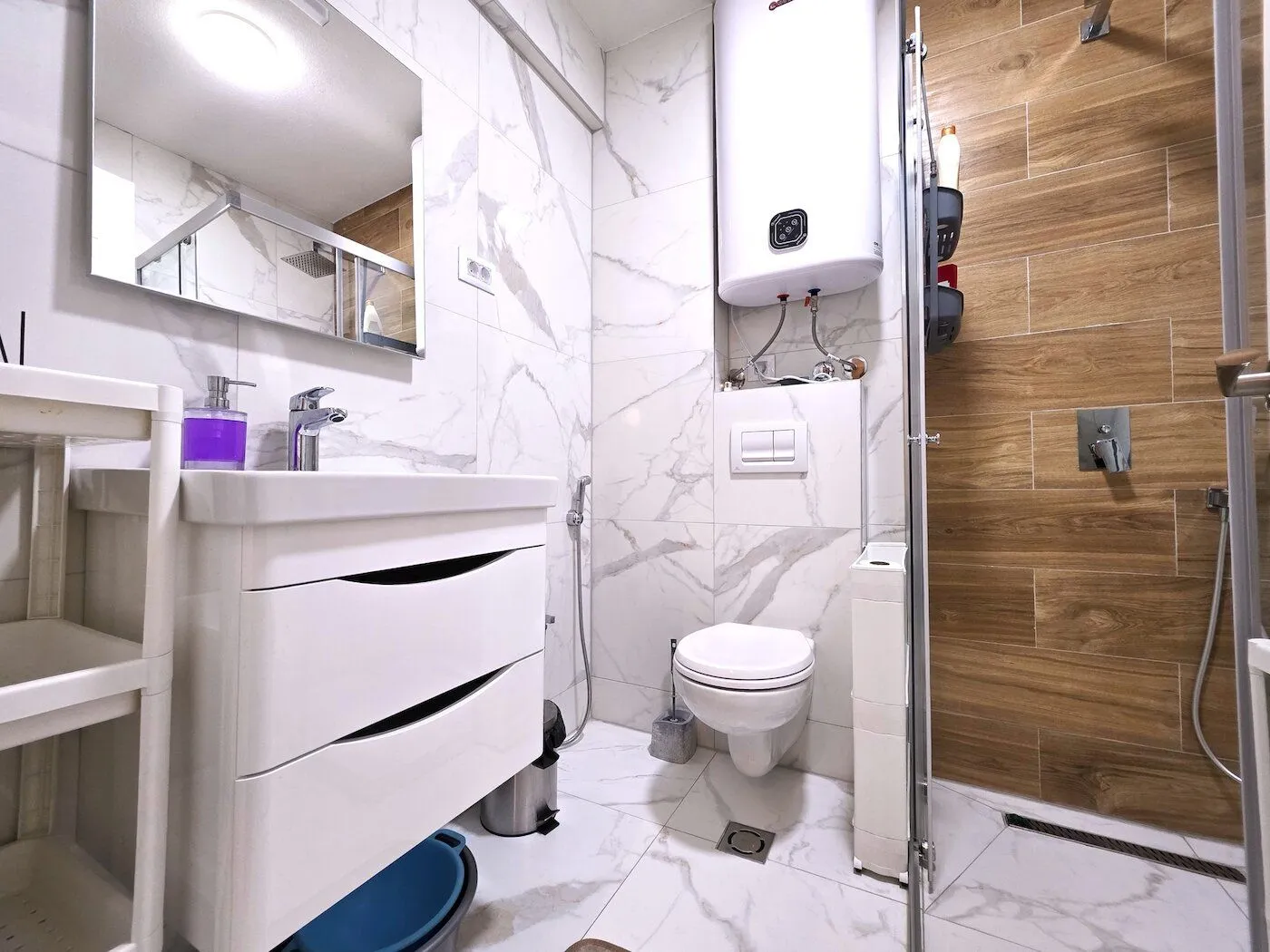 A tidy bathroom with a washbasin, toilet, and walk-in shower.