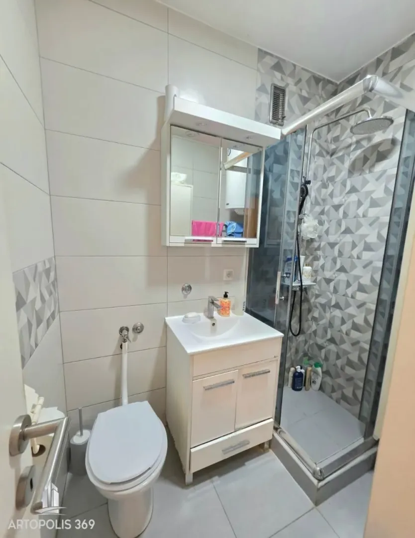 Kupatilo opremljeno umivaonikom, wc šoljom i tuš kabinom.