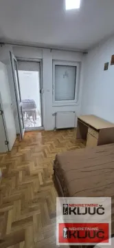 Nameštena spavaća soba sa krevetom, radnim stolom i izlazom na terasu. - image 3