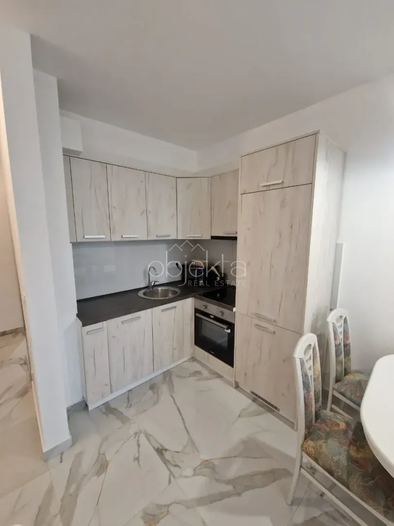 Small kitchen with wooden elements and a dining table nearby.
