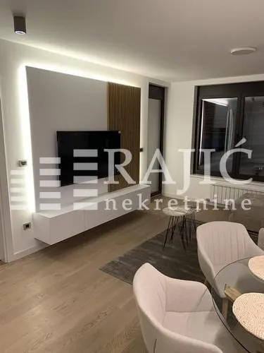 Moderan dnevni boravak sa TV komodom i trpezarijskim stolom.