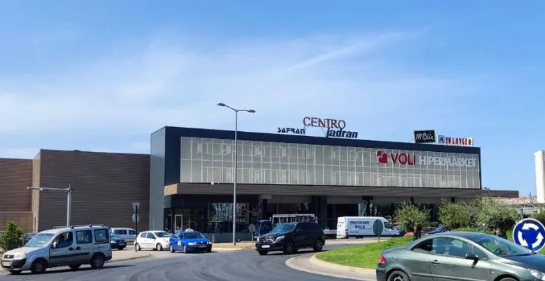 Exterior view of the shopping mall with a parking area and roundabout.