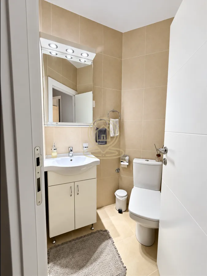 Small bathroom with a washbasin, mirror, and toilet.
