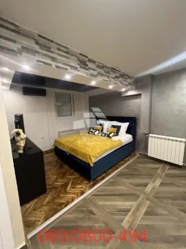 Nameštena spavaća soba sa bračnim krevetom i komodom sa televizorom. - image 5