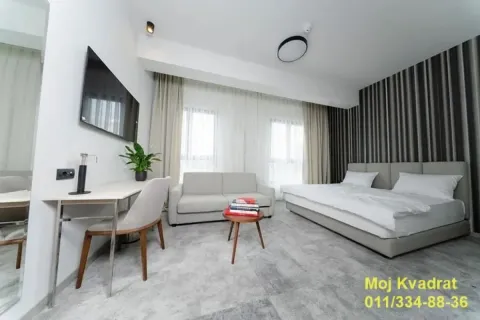 Modern bedroom with a double bed, sofa, desk, and television. - image 4