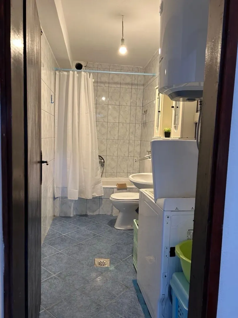 View of a small bathroom with a bathtub, sink, and toilet.
