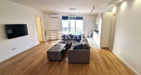 Spacious living room connected to the kitchen, featuring a sofa set and hardwood flooring. - image 2