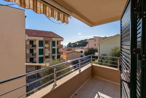 Small tiled balcony with a metal railing and a view of surrounding buildings and the neighborhood. - image 6
