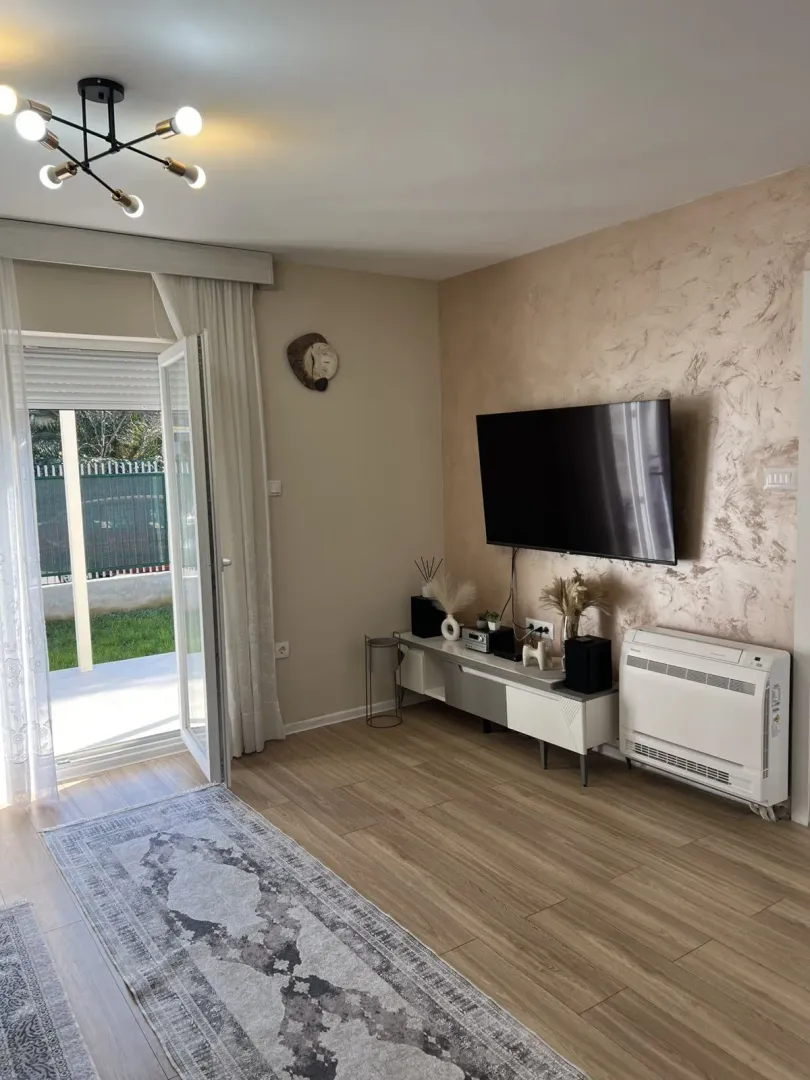 Bright living room with a TV and access to the yard.