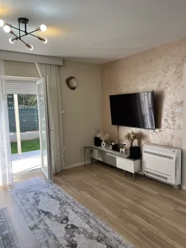 Bright living room with a TV and access to the yard. - image 12