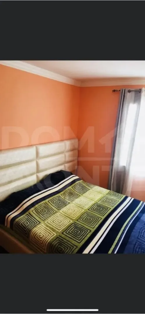Bedroom with a double bed and orange walls.